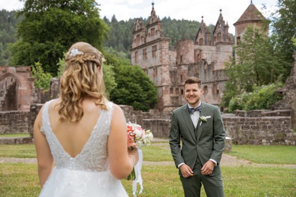 Emotionaler First Look eines Brautpaares vor historischem Schloss – professionelle Hochzeitsfotografie in Baden-Württemberg.
