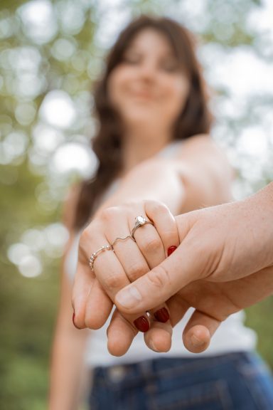 Glückliche Braut präsentiert ihren funkelnden Verlobungsring nach einem romantischen Heiratsantrag.